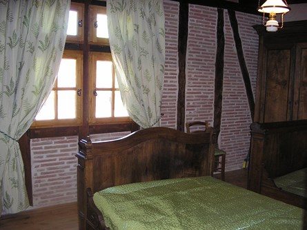 Le-moulin-de-maraval-cordes-sur-ciel-chambre-verte-7 Chambre rustique avec deux lits anciens 120, fenêtres à meneaux, colombages parquet ancien.