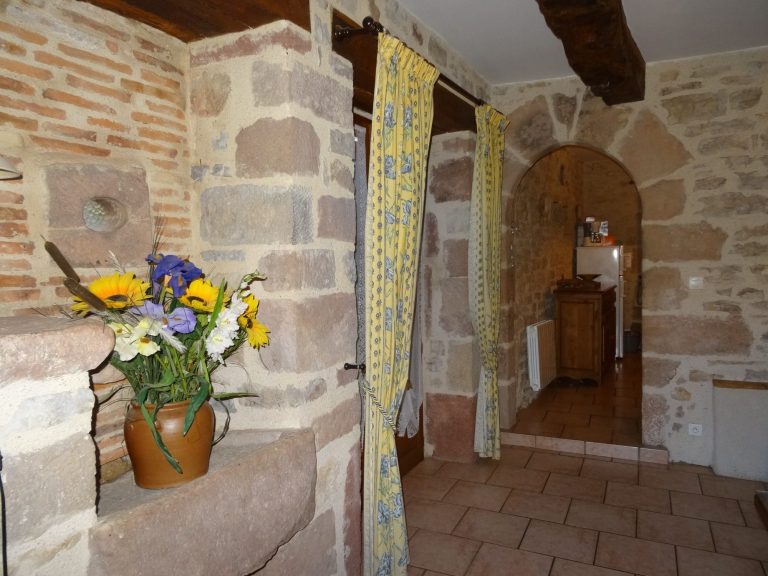 Entrée intérieur en pierre et poutres apparentes